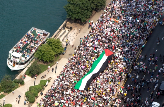 Large crowd march with huge Palestinan Flag